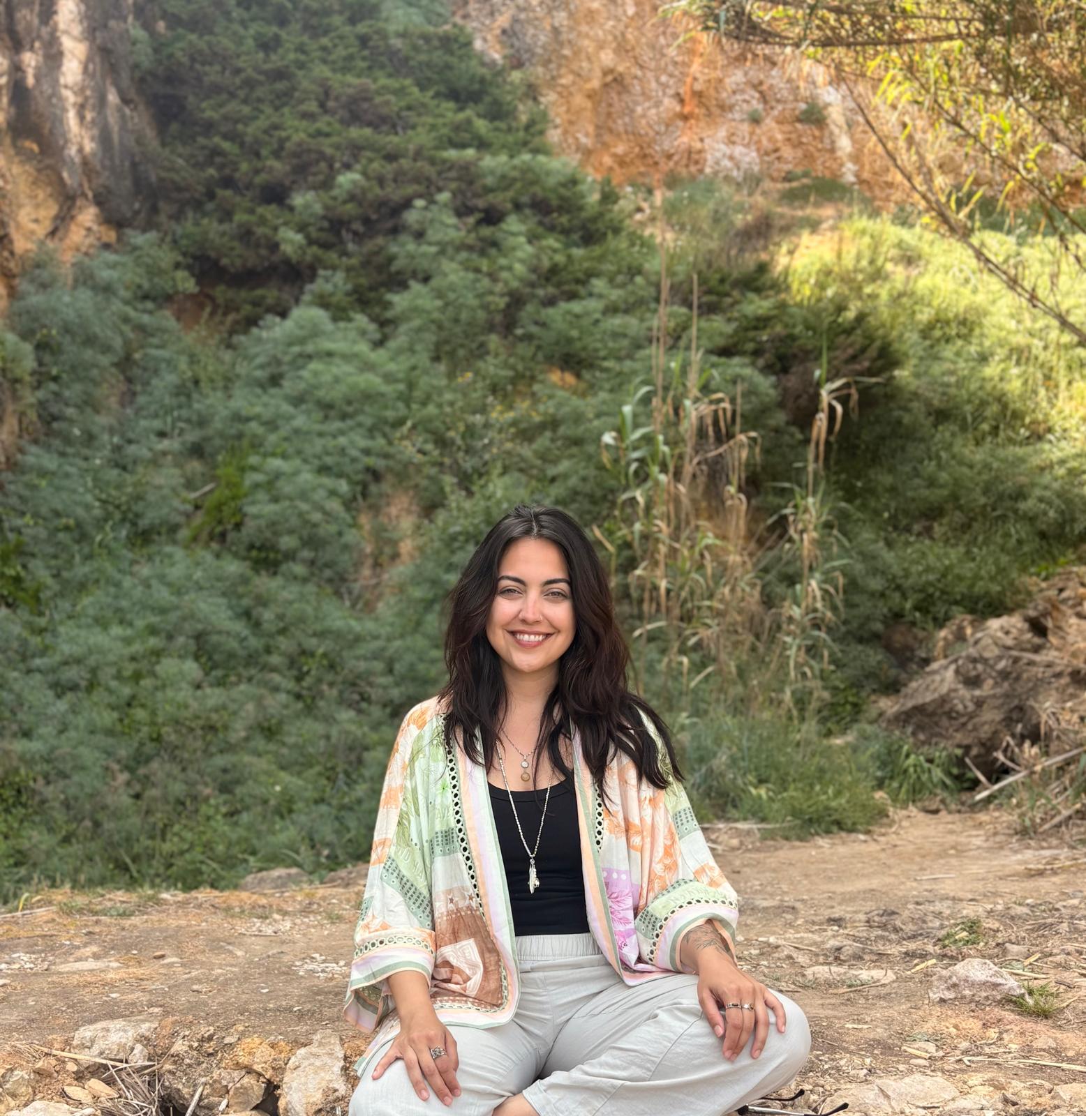 Aghatta Ortigosa, terapeuta integrativa, sentada em serenidade na natureza